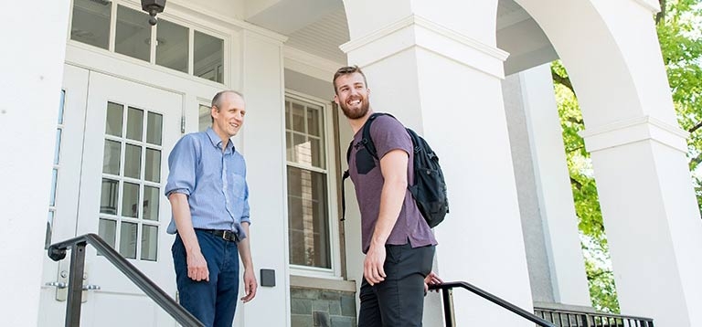 A student and professor outside one of the entrances to Lippman Hall