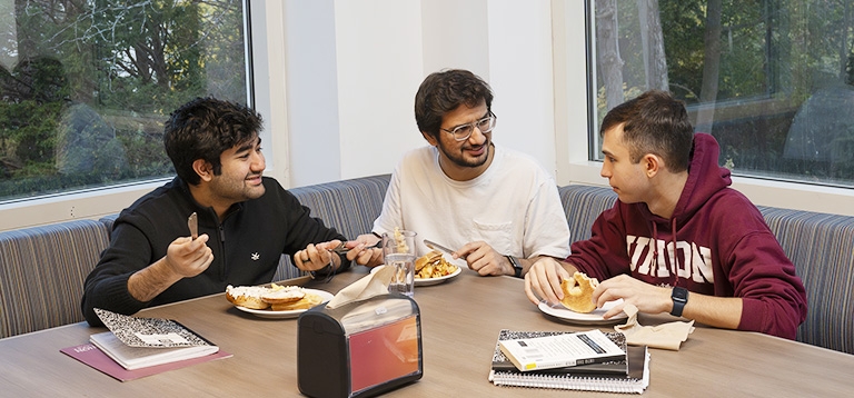 Three students enjoying a tasty meal in the Reamer Dining space.