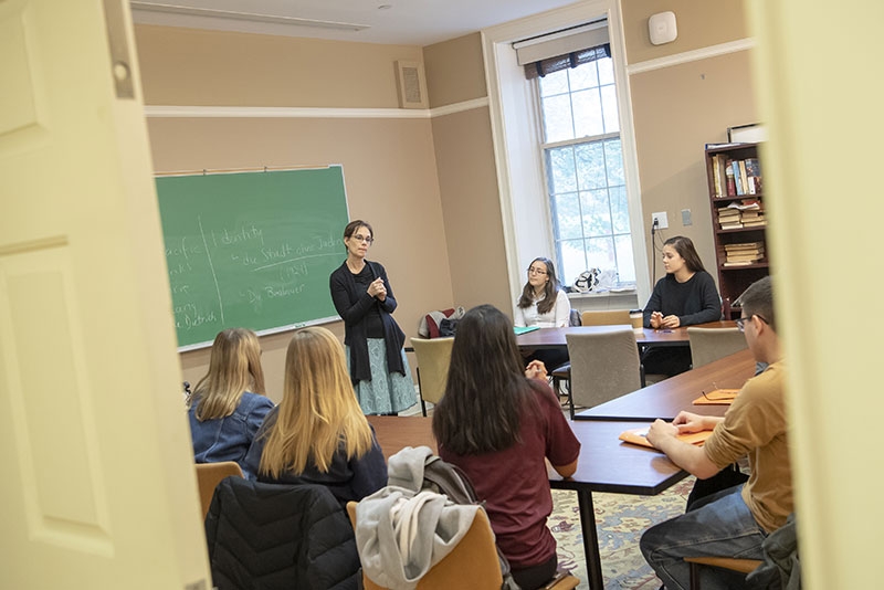 A professor lecturing in front of a blackboard