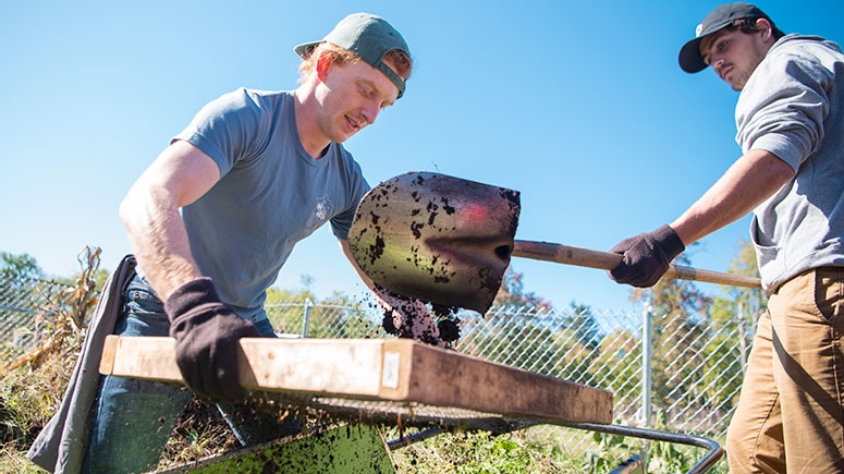 Students with shovels cleaning up a local park